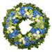 Trauerkranz online in wunderschöpnem elden Blau. Handgebunden mit weißen Rosen und blauen Hortensien. Euroflorist Trauerfloristik.
