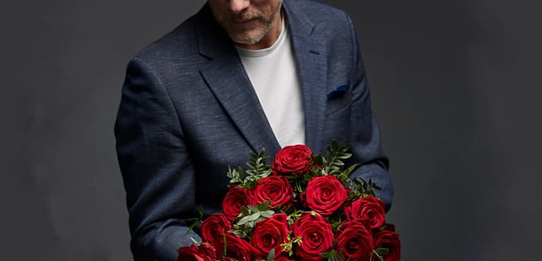 Mann mit großem Blumenstrauß aus Rosen